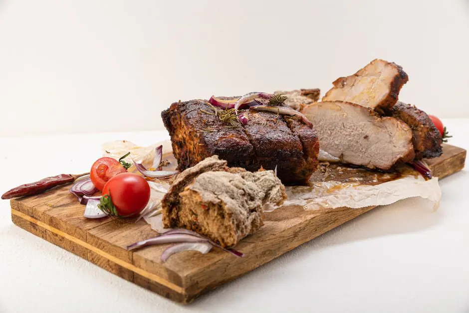Rôti de porc assaisonné et préparé pour la cuisson au four avec herbes aromatiques